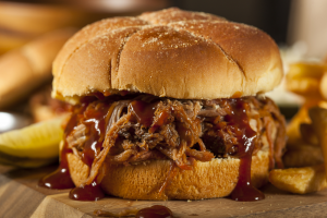 chop bbq sandwich with bbq sauce pouring out the sides. 